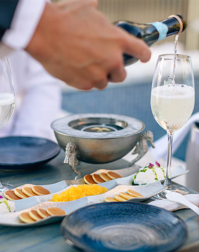 Champagne pour and a table with caviar setting.